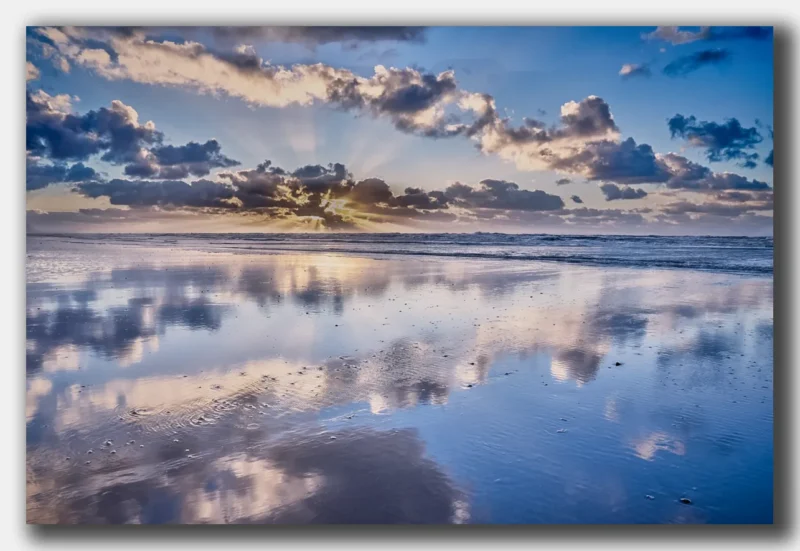 Noordzeekust met strand en Noordzee bij zonsondergang